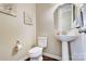 Small powder room with pedestal sink, toilet, and octagonal mirror at 14818 Long Iron Dr, Huntersville, NC 28078