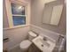 Clean bathroom with a toilet, sink, and vanity mirror at 1601 Lyndale Pl, Charlotte, NC 28210