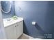 Small bathroom with white vanity and blue walls at 182 Water Oak Dr, Pineville, NC 28134