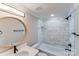 Modern bathroom with marble tile, a shower/tub combo, and a circular mirror at 277 Melrose Sw Dr, Concord, NC 28025