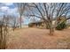 A leafy front yard with a charming brick home and covered front porch and mature trees at 3050 Wilkesboro Hwy, Statesville, NC 28625