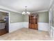 Traditional dining room boasts decorative chair rail, classic chandelier, and tile flooring at 330 Regency Rd, Salisbury, NC 28147