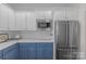 Modern kitchen with stainless steel appliances and white and blue cabinets at 3319 Holt St, Charlotte, NC 28205