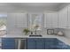 White and blue kitchen with stainless steel appliances and a farmhouse sink at 3319 Holt St, Charlotte, NC 28205