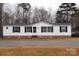 White single-wide manufactured home with brick skirting and black shutters at 334 Stanley Spencer Mtn Rd, Gastonia, NC 28056