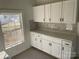 White kitchen cabinets with gray tile backsplash at 518 W White St, Chester, SC 29706