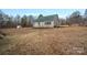 Tan house with green roof, large yard, and detached shed at 5605 Miami Ln, Concord, NC 28025