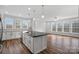 Modern kitchen with white cabinets, island, and stainless steel appliances at 5605 Miami Ln, Concord, NC 28025