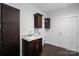 Laundry room with dark brown cabinets, utility sink, and built-in shelving at 5605 Miami Ln, Concord, NC 28025