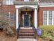 Brick front porch with a dark blue front door at 585 Ambergate Nw Pl, Concord, NC 28027