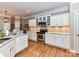 Eat-in kitchen with white cabinets, granite countertops, and a view at 585 Ambergate Nw Pl, Concord, NC 28027