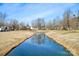 Serene community pond reflecting trees and sky at 6033 Creft Cir, Indian Trail, NC 28079