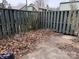 Small backyard with a wooden fence and leaf-covered ground at 6126 Bent Tree Ct, Charlotte, NC 28212