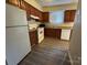 Kitchen with laminate floor, white appliances, and wood cabinets at 6126 Bent Tree Ct, Charlotte, NC 28212