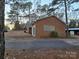 Brick house exterior with a gravel driveway and surrounding trees at 625 Teddar Rd, Mount Gilead, NC 27306