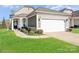 Charming single-story home featuring a two-car garage, well-maintained lawn, and inviting front entrance at 8024 Carolina Lakes Way, Fort Mill, SC 29707
