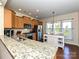 Open kitchen with granite counters, stainless appliances, an island, a tile backsplash, and hardwood floors at 8024 Carolina Lakes Way, Fort Mill, SC 29707