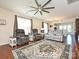 Cozy living room with ample seating, a ceiling fan, and natural light from the windows at 8024 Carolina Lakes Way, Fort Mill, SC 29707