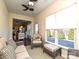 Cozy sunroom featuring wicker furniture, neutral decor, views to the yard, and adjacent to the kitchen at 8024 Carolina Lakes Way, Fort Mill, SC 29707