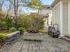 Outdoor patio with fire pit, stone seating wall, and wood storage at 813 Garbow Ct, Charlotte, NC 28270