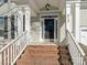 Brick steps leading to a covered porch with white columns and a black front door at 813 Garbow Ct, Charlotte, NC 28270