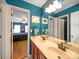 Shared bathroom with double vanity and teal walls at 8440 Mossy Cup Trl, Harrisburg, NC 28075