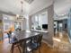 Bright dining area features a farmhouse table and chairs, with views into the living room at 8440 Mossy Cup Trl, Harrisburg, NC 28075