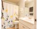 Bright bathroom with shower/tub combo, white vanity, and floral shower curtain at 9009 Powder Works Dr, Huntersville, NC 28078