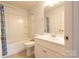 A well lit bathroom featuring a tub shower and white vanity with shaker style cabinets at 9009 Powder Works Dr, Huntersville, NC 28078