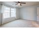 Bright bedroom featuring neutral carpeting, ceiling fan, and a large window with curtains at 9009 Powder Works Dr, Huntersville, NC 28078