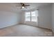 Bright bedroom featuring neutral carpeting, ceiling fan, and a large window at 9009 Powder Works Dr, Huntersville, NC 28078