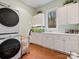 Bright laundry room with white cabinets and a stacked washer/dryer at 9117 Monarchos Ct, Waxhaw, NC 28173