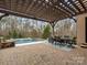 Relaxing patio with pergola, dining set, and view of the pool at 9117 Monarchos Ct, Waxhaw, NC 28173