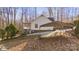 Back view of a home with a covered back deck, a carport, and a wooded yard at 926 Lone Oak Ln, Mooresville, NC 28115