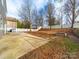 Large backyard featuring a patio, a built-in brick fire pit, and a white picket fence at 1120 Spicewood Pines Rd, Fort Mill, SC 29708