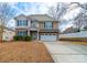 Attractive two-story home featuring stone accents, blue shutters, a two-car garage and meticulous landscaping at 1120 Spicewood Pines Rd, Fort Mill, SC 29708