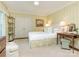 Comfortable bedroom with light yellow wallpaper, white carpet, a bed with a cushioned headboard, and matching side tables at 1136 Bolling Rd, Charlotte, NC 28207