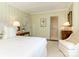 Bedroom with light-yellow striped wallpaper, a bed with a white comforter, and an open bathroom doorway at 1136 Bolling Rd, Charlotte, NC 28207