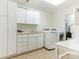 Well-organized laundry room with white cabinets, modern appliances, and ample countertop space at 1136 Bolling Rd, Charlotte, NC 28207