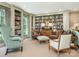 A room with floor-to-ceiling bookshelves filled with volumes, with plush leather chairs for reading at 1136 Bolling Rd, Charlotte, NC 28207