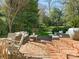 Brick patio with multiple seating areas surrounded by lush greenery and landscaping at 1136 Bolling Rd, Charlotte, NC 28207