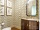 Charming powder room with patterned wallpaper, elegant fixtures, and a stylish mirror at 1136 Bolling Rd, Charlotte, NC 28207