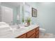 Bright bathroom with wooden vanity, white countertops, and fresh white towels at 135 Singleton Rd, Mooresville, NC 28117