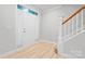 Bright foyer featuring light wood floors, a modern door, and staircase leading to upper level at 135 Singleton Rd, Mooresville, NC 28117