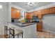 Well-lit kitchen featuring wooden cabinetry, granite countertops, and breakfast bar seating at 135 Singleton Rd, Mooresville, NC 28117