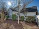 Cozy backyard patio with stone retaining wall, landscaping, and string lights at 13713 Batemans Rd, Huntersville, NC 28078