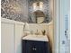 Stylish powder room with patterned wallpaper, a pedestal sink, and gold fixtures at 13713 Batemans Rd, Huntersville, NC 28078