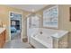 Relaxing bathroom with a soaking tub, glass-enclosed shower, and view to bedroom with ceiling fan at 153 Snead Rd # 72, Fort Mill, SC 29715