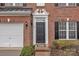 Close-up of a brick facade townhome with a black front door, garage, and manicured landscaping at 153 Snead Rd # 72, Fort Mill, SC 29715