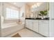 Bathroom with soaking tub, granite countertop, and white cabinets at 172 Longleaf Dr, Mooresville, NC 28117